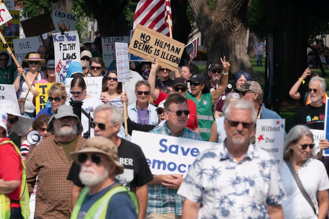 Cartazes contra o governo Trump são vistos durante o protesto "Rage Against the Regime" 50501 no centro de Topeka em 2 de agosto de 2025.