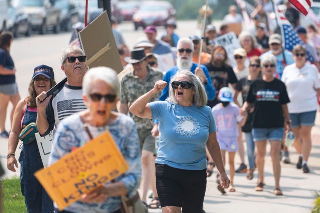 Kevin e Shelley Brent, de Altoona, marcham com manifestantes durante um protesto da Fúria Contra o Regime no Capitólio Estadual de Iowa, em 2 de agosto de 2025, em Des Moines. O protesto contou com a participação de outros manifestantes em todos os Estados Unidos.